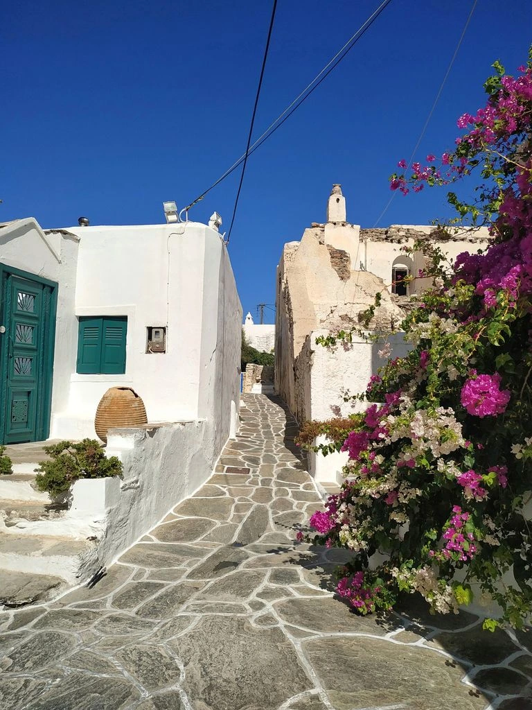 Callejones encalados en una isla griega del Egeo con cúpulas azules